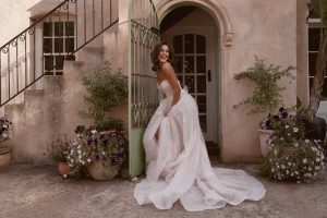 bride wearing new bridal gown from Anna Campbell bridal collection Bloom 2024 in doorway of mediterranean style home