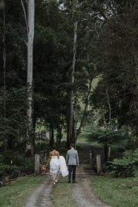 bride and groom walking across bridge on private property wedding venue on the Sunshine Coast