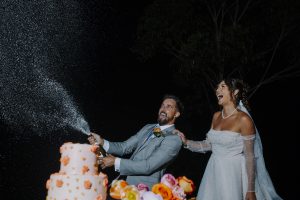 bride and groom doing champagne spray at their outdoor wedding reception