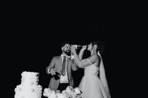 black and white image of bride and groom having champagne spray toast