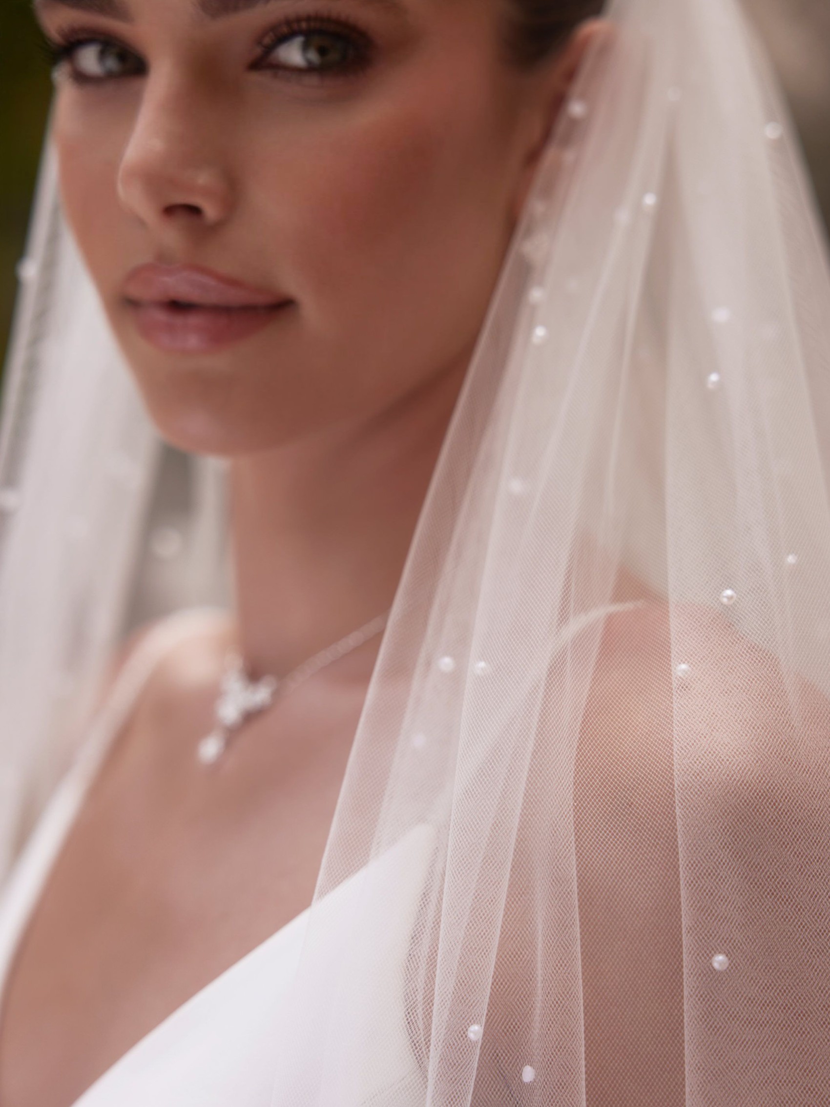 close up of bride wearing veil with pearls