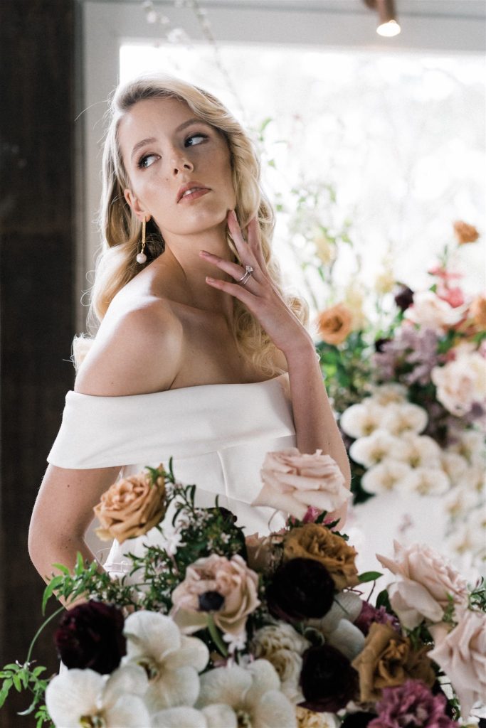 Bride holding bridal bouquet of neutral and dark blooms at Yarrabee Homestead wedding styled by Sunshine Coast florist