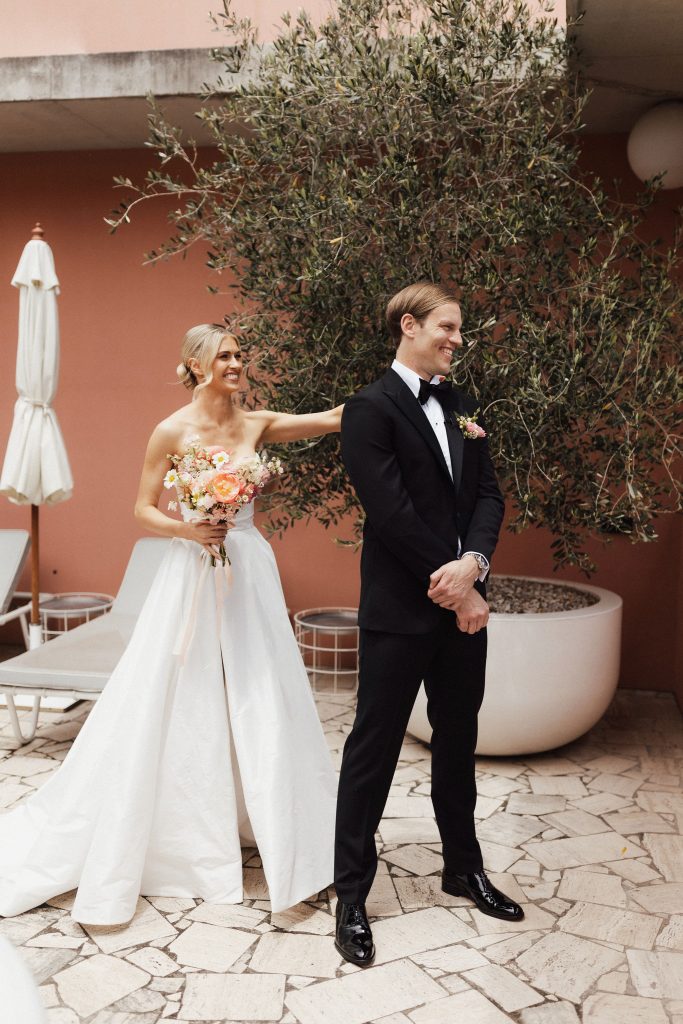 Bride tapping groom on the shoulder for first look