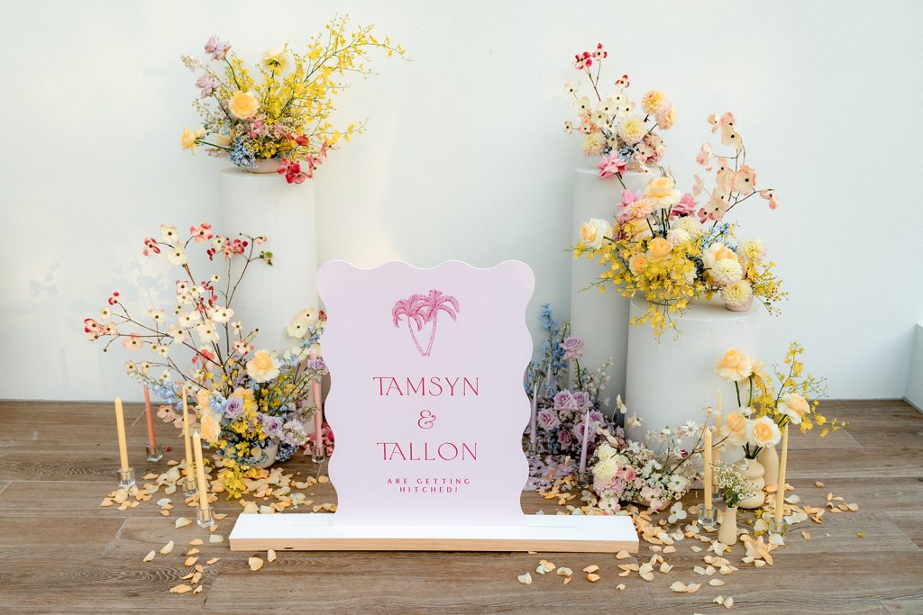 Pastelle rainbow wedding ceremony flowers and signage