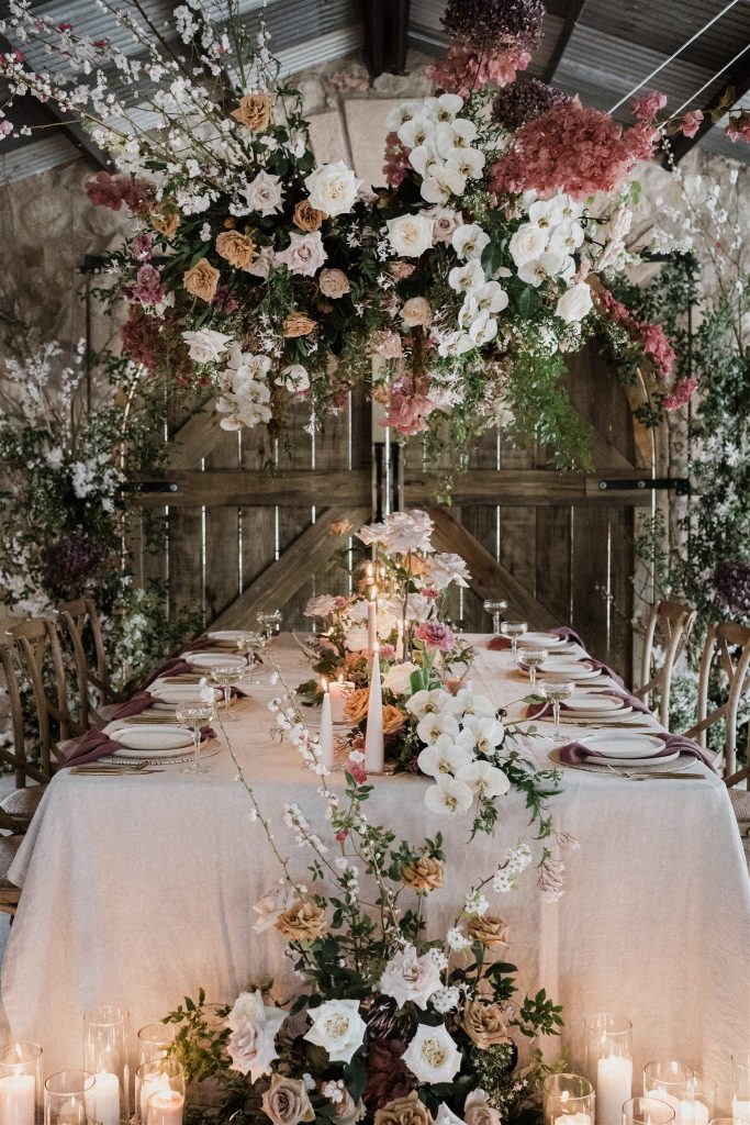 Elegant wedding reception table with hanging floral installation by a Sunshine Coast wedding florist