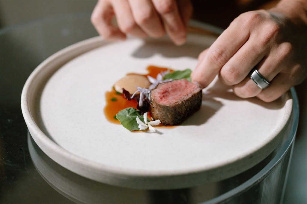wagyu beef in jus being plated by Alan Dawes private chef sunshine coast