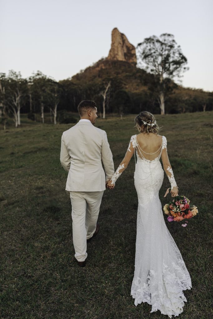 Bride and Groom walking towards Glasshouse Mountains