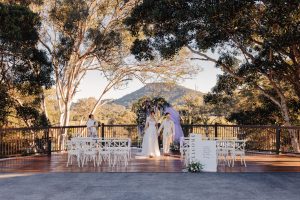 wedding ceremony with lavender colour palette set up on deck between trees at sunshine coast wedding venue Yandina Station